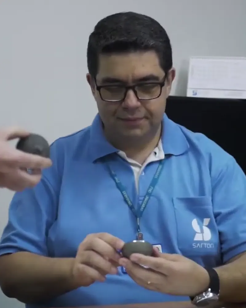 Engenheiro da Sartori avaliando um componente protótipo na mesa de projeto
